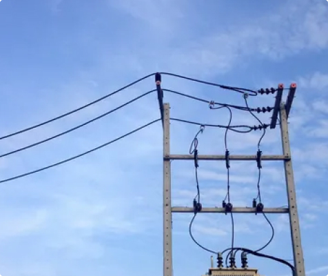 High-voltage power transformer installed at an electrical substation with bushings, cooling radiators, and overhead transmission connections.