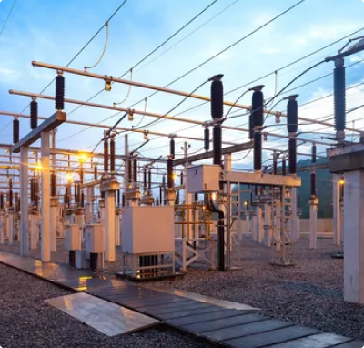 A perspective view of an outdoor electrical substation at dusk, showing rows of high-voltage circuit breakers, insulators, and busbars connected by overhead power lines.