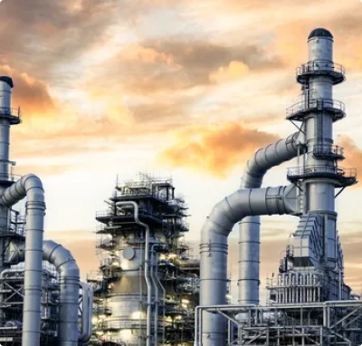 Large petrochemical refinery with tall distillation towers, pipelines, and industrial processing units under a dramatic sky.