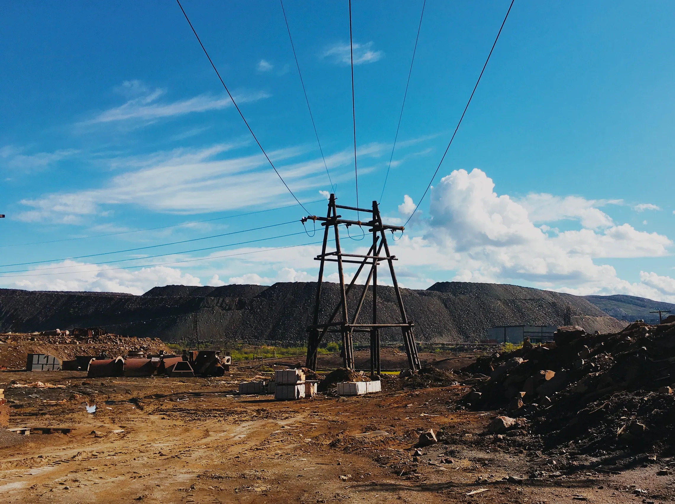 High-voltage power transformer installed at an electrical substation with bushings, cooling radiators, and overhead transmission connections.
