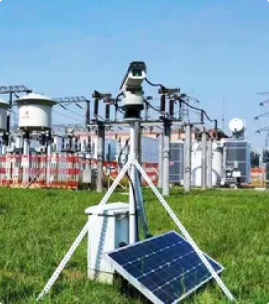 Industrial monitoring device mounted on a pole with dual sensor units, warning label, and weatherproof control enclosure.